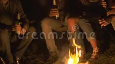 一群朋友在森林的篝火前喝啤酒，玩得开心